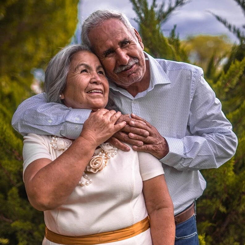 man in white dress shirt hugging woman in white dress